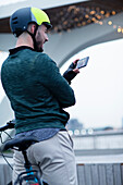 Man in bike helmet video chatting with smartphone