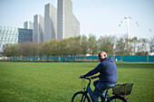 Happy man riding bicycle in urban park