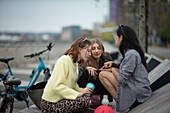 Young female friends talking in city