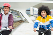 Happy teen friends riding bicycles in city