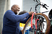 Happy man placing bicycle on car bike rack in city