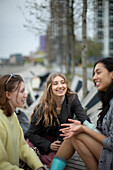 Happy young female friends talking in city