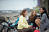 Happy young female friends laughing in city