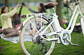 Friends enjoying picnic behind bicycle parked in park
