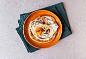Paratha with garlic yoghurt, runny fried egg, bacon and chilli oil
