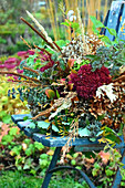 Herbstlicher Blumenstrauß auf Gartenstuhl