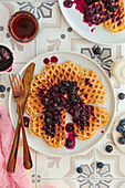 Waffle with cooked blueberries and maple syrup