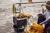 Grillen von Maiskolben am Strand in Thailand