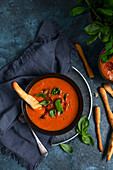 Tomato soup with roasted cherry tomatoes, basil and bread sticks