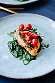 Chicken breast 'bruschetta' on spinach leaves