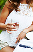 Woman in summer clothes holding a glass of spritzer with rosé wine and vodka