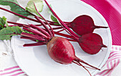 Beetroot, two plants on a white plate, one cut open