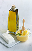 Three different types of fat: olive oil, clarified butter, coconut oil
