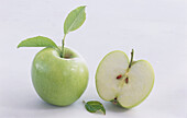 Whole apple with leaf and an apple half