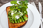 Toast with green asparagus, poached egg and watercress