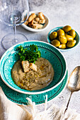 Vegetarische Pilzsuppe mit grünen Oliven und Croutons