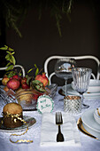 Festlich gedeckter Weihnachtstisch mit weißer Tischdecke und Obstkorb