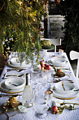 Festlich gedeckter Weihnachtstisch mit weißer Tischdecke und Goldakzenten