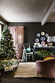 Decorated Christmas tree in the living room; console table and wall plates in the background