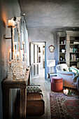 Sammlung von Glas-Kerzenhaltern auf Holztisch in weihnachtlich dekoriertem Wohnzimmer