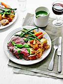 Roast beef with watercress sauce, roast potatoes and vegetables