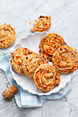 Mini spiral pizzas with potatoes, ham, carrots, sweetcorn and cheese