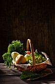 Korb mit frischen Karotten, Bohnen Chinakohl, Romanesco, Erbsenschoten, Kohlrabi und Avocado