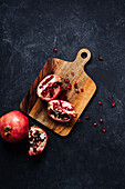 Pomegranate on wooden cutting board and dark background