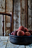 Lychees in ceramic bowl on rustic wooden table