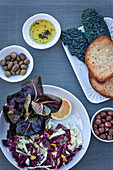 Vegan salad with vinaigrette; olives and bread