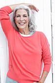 Mature woman with grey hair in salmon jumper
