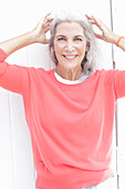 Mature woman with grey hair in salmon jumper