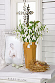 Snowdrops in vase, bird figure in nest and speckled Easter eggs