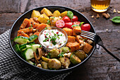 Vegan bowl with sweet potatoes, potatoes, vegetables and herb dip