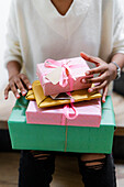 Young woman with stack of wrapped gifts