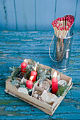 Carton with old baubles and red candles, matches