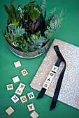 Hyacinths potted in old baking pan and wrapping paper decorated with letter tiles