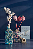 Dried flowers in vases decorated with macrame