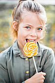 Portrait of girl licking lollipop