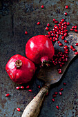 Two whole pomegranates, pomegranate seed and cleaver