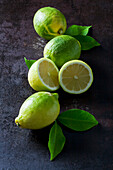 Green organic lemons on dark background