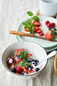 Germany, Bowl of breakfast yogurt with fruits and mint