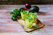 Gläser Avocadocreme mit Chiliflocken, Kresse und Petersilie