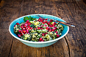 Bowl of bulgur wheat salad with cucumber, herbs, pomegranate seed and parsley