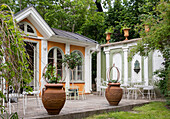 Terrasse mit Terrakottatöpfen vor der Orangerie und der Gartenmauer