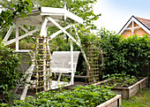 Antique garden swing with raised beds in front of it