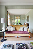 Living room with light green walls, patterned curtains and yellow sofa