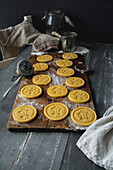 Raw short crust motif cookies and cookie stamp on wooden board
