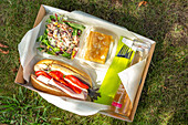 Lunchbox mit Schinkenbrötchen, Bohnensalat und Kuchenstück