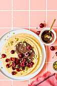 Crepes with chocolate spread, cherries and pistachios